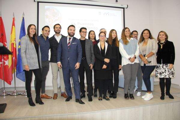 Foto-familia-participantes-puentes-talento-y-autoridades-Ayuntamiento-de-Madrid-sobre-escenario-del-centro-innovación-Ilab