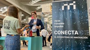 Jóvenes emprendedores en evento de Madrid Innovation y roll up promocional de MI